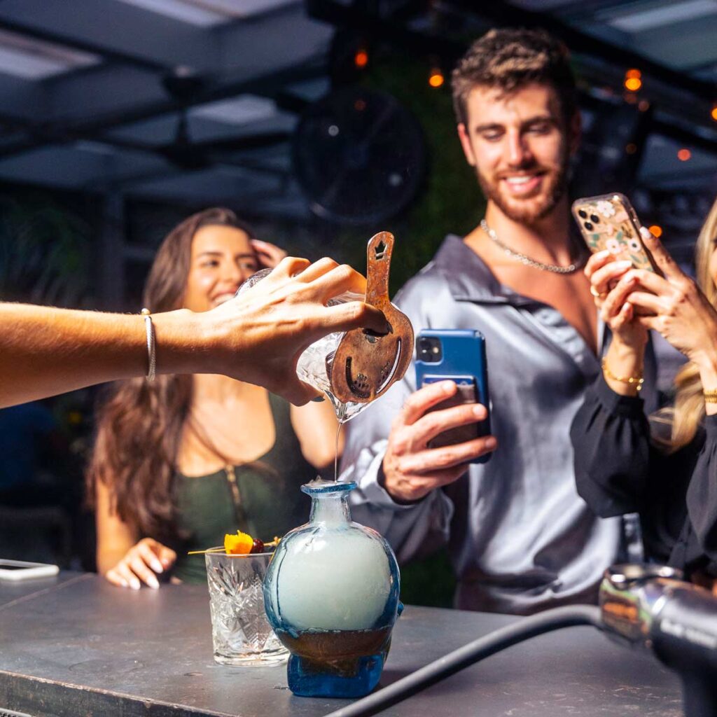 bartender making cocktails for group of friends